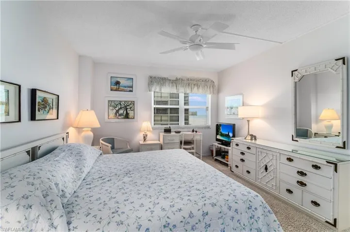 Carpeted bedroom featuring a textured ceiling and a ceiling fan