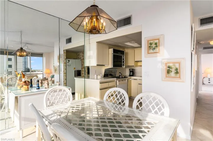 Dining space featuring light tile patterned floors and suspended lighting