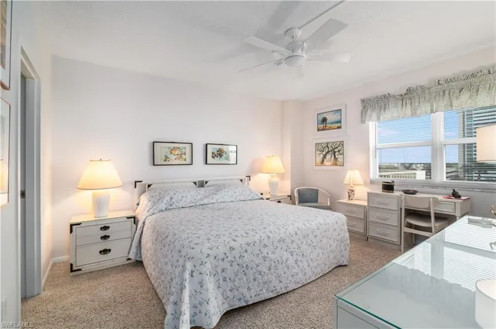 Bedroom featuring a ceiling fan, light colored carpet, and a textured ceiling