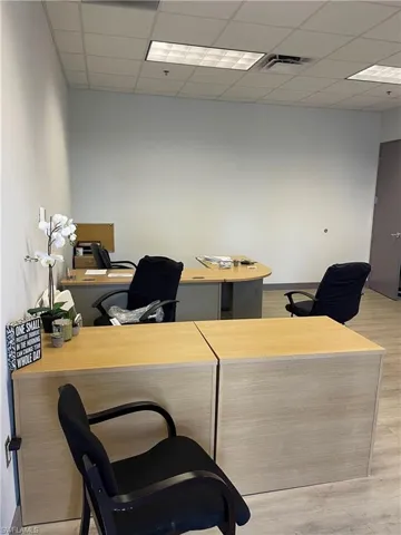 Office space featuring a drop ceiling and light hardwood / wood-style floors