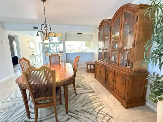 Dining room with light tile patterned floors and a notable chandelier