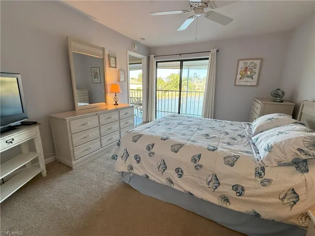 Master bedroom with carpet, ceiling fan, and access to outside