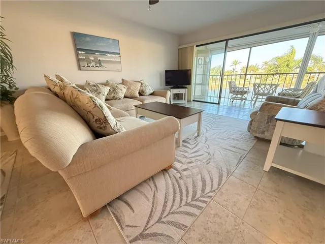 Living room featuring tile patterned floors and ceiling fan