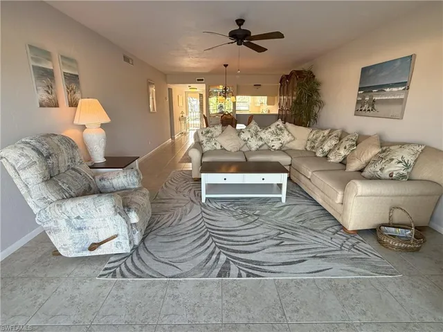 Living room with ceiling fan looking back to dining room & kitchen