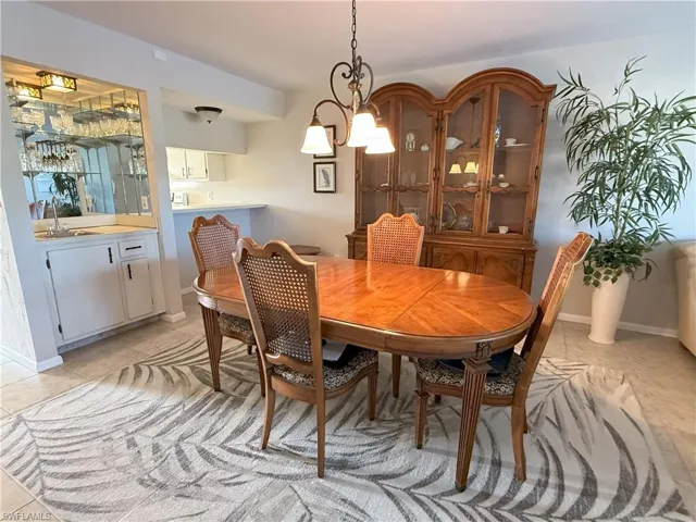 Tiled dining area with a notable chandelier and wet bar