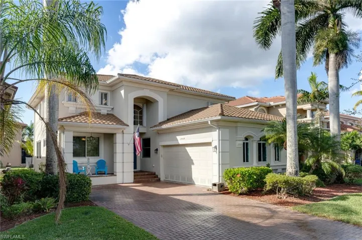 Mediterranean / spanish-style house featuring a tiled roof, stucco siding, and decorative driveway
