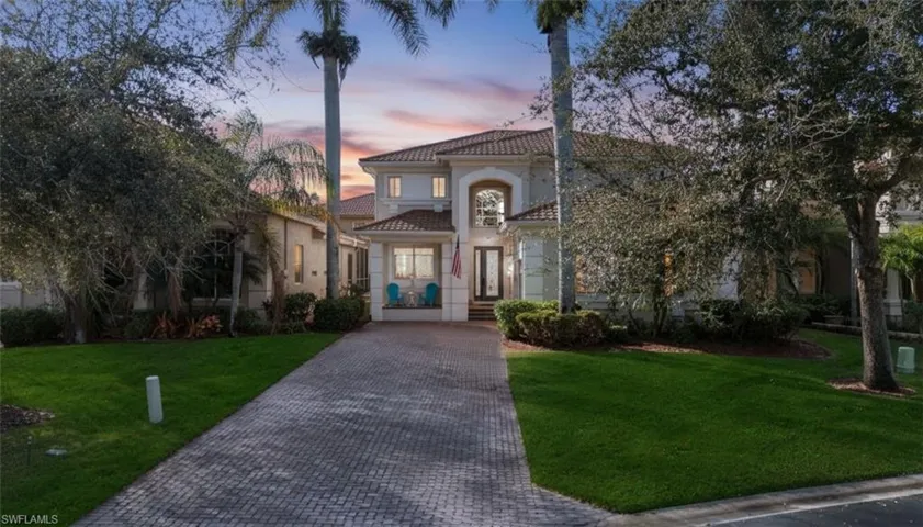 Mediterranean / spanish home featuring a lawn, stucco siding, and a tiled roof