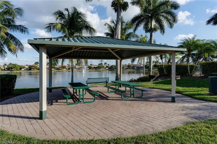 View of property's community with a water view, a patio, and a lawn