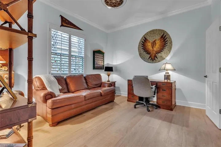 Wood-finish flooring, crown molding, plantation shutters, and a decorative ceiling medallion
