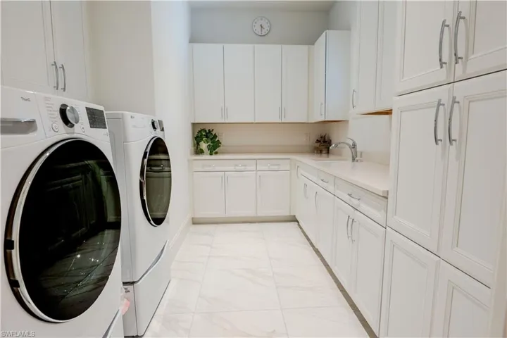 Laundry room featuring cabinets, sink, and washer and dryer