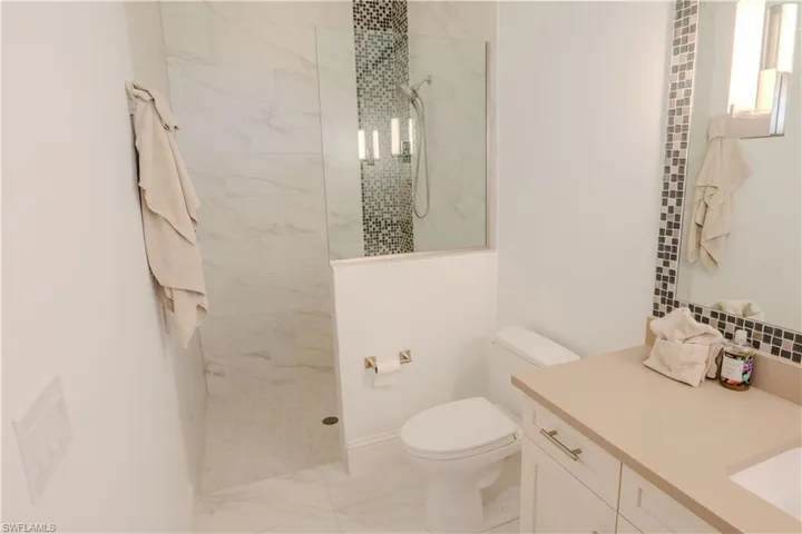 Bathroom with toilet and tiled shower
