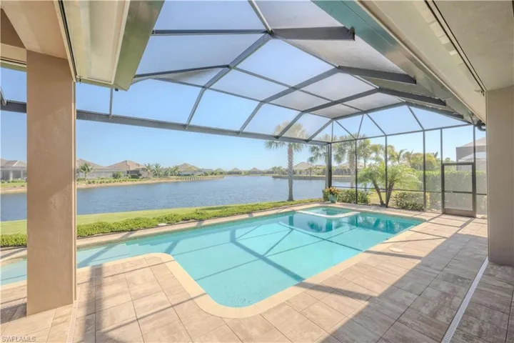 View of swimming pool with a lanai, a water view, and a patio