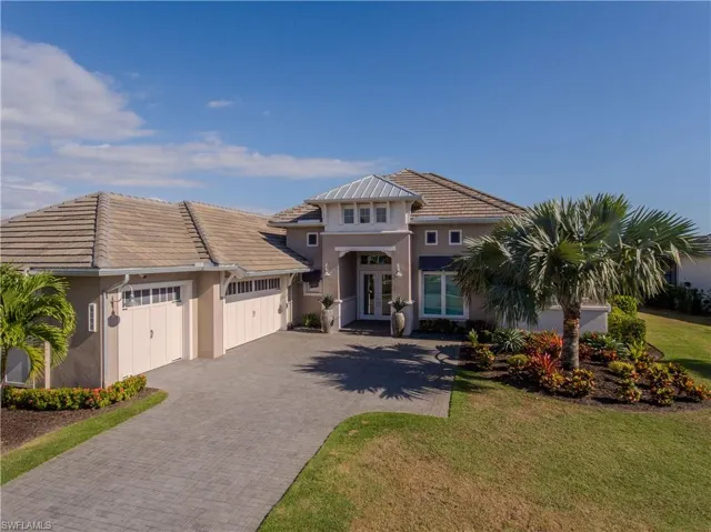 View of front of property featuring a front yard, french doors, and a garage