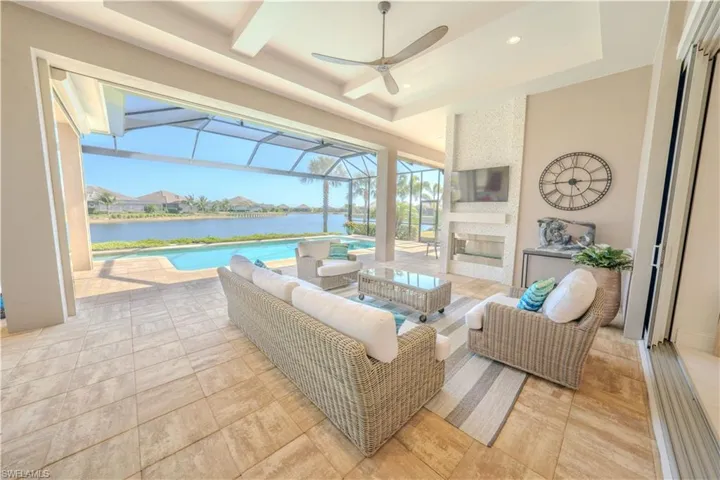 View of patio / terrace with an outdoor living space with a fireplace, glass enclosure, and a water view