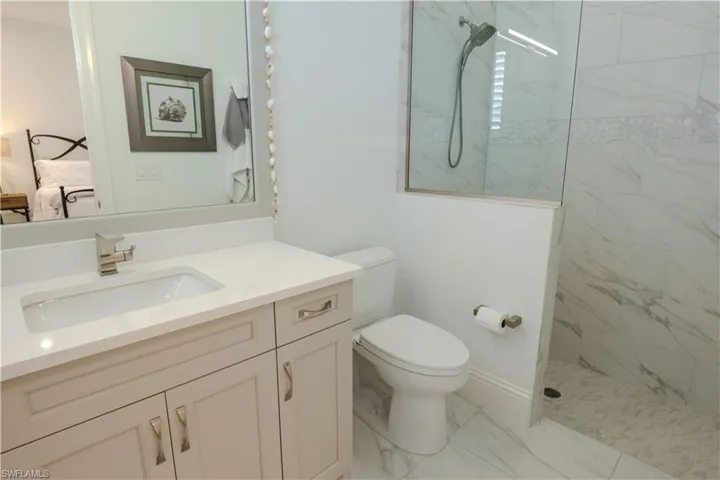 Bathroom with vanity, toilet, and a tile shower
