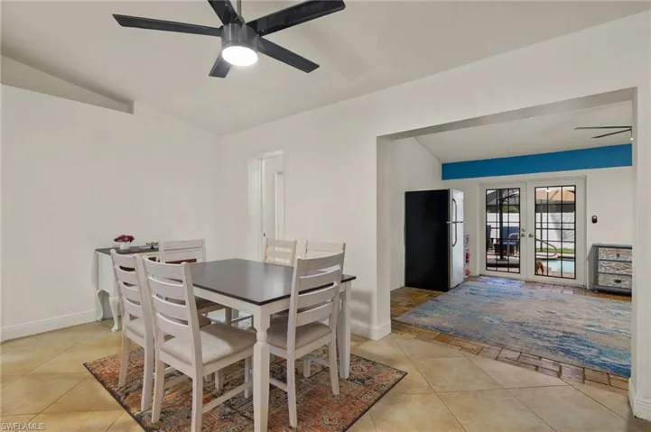 Dining room featuring french doors, ceiling fan, lofted ceiling, and light tile patterned floors