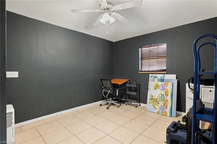 Office space with light tile patterned floors and ceiling fan
