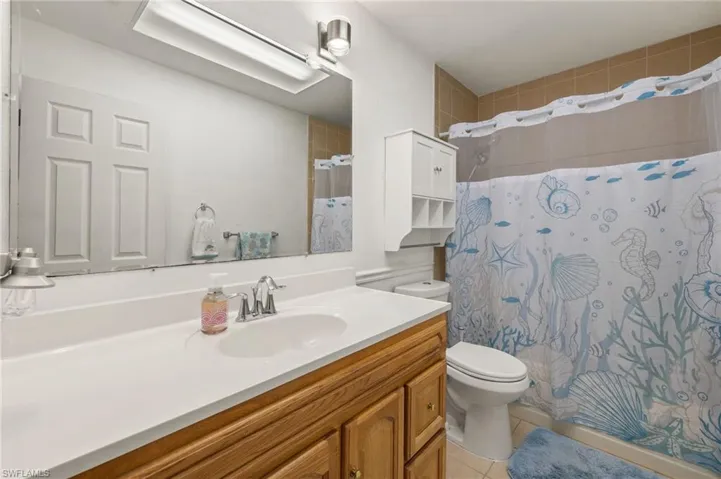 Bathroom featuring tile patterned flooring, toilet, and vanity