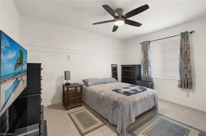 Bedroom featuring light tile patterned flooring and ceiling fan