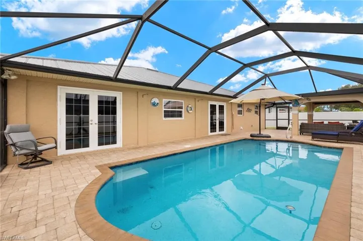 View of swimming pool featuring french doors, a patio area, and a lanai