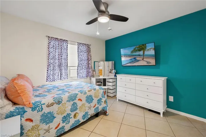 Bedroom with ceiling fan and light tile patterned floors