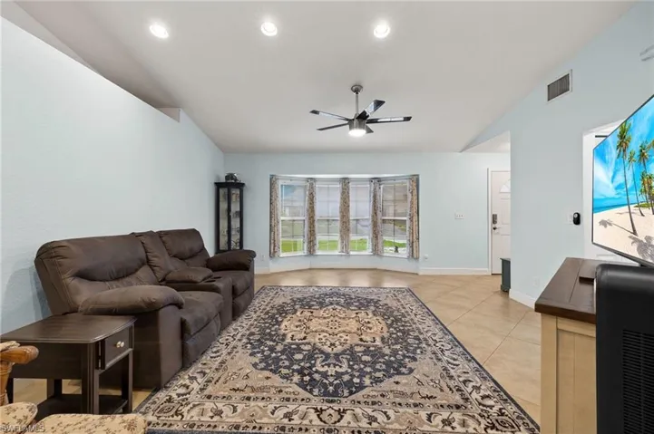 Living room featuring light tile patterned flooring and ceiling fan