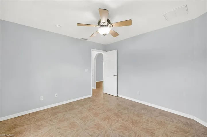 Spare room with ceiling fan and light tile patterned floors