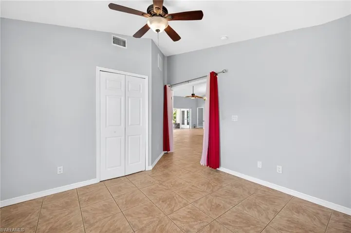 Unfurnished bedroom with light tile patterned floors, a closet, and ceiling fan
