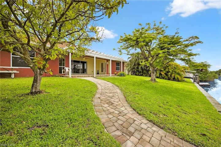 View of front of house featuring a front lawn and stucco siding