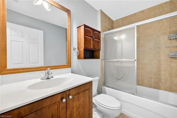 Full bath featuring vanity and enclosed tub / shower combo