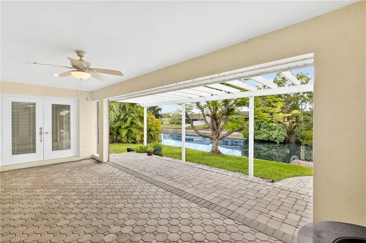 View of patio featuring french doors, ceiling fan, and a water view