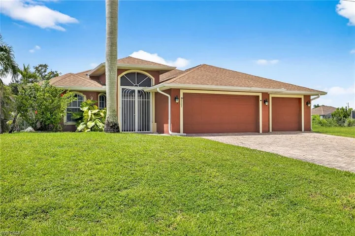 View of front facade featuring an attached garage, roof with shingles, a front yard, and decorative driveway