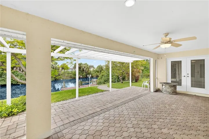 Unfurnished sunroom featuring french doors, ceiling fan, and a water view