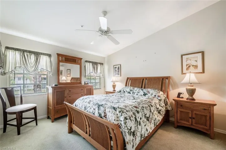 Bedroom featuring baseboards, a ceiling fan, and light colored carpet