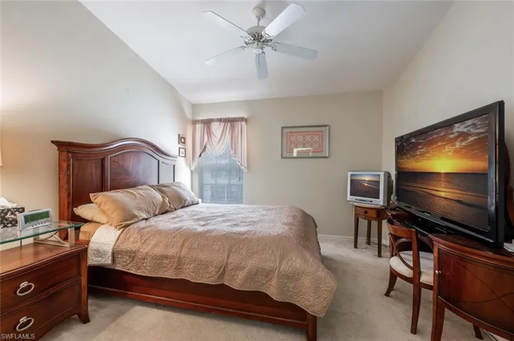 Bedroom featuring a ceiling fan, light carpet, and baseboards
