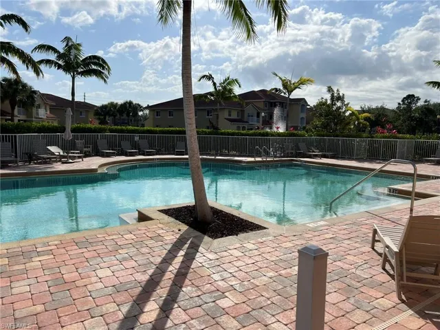 Pool with a patio, a residential view, and fence