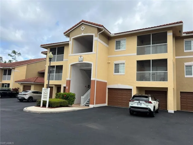 View of building exterior featuring driveway and an attached garage