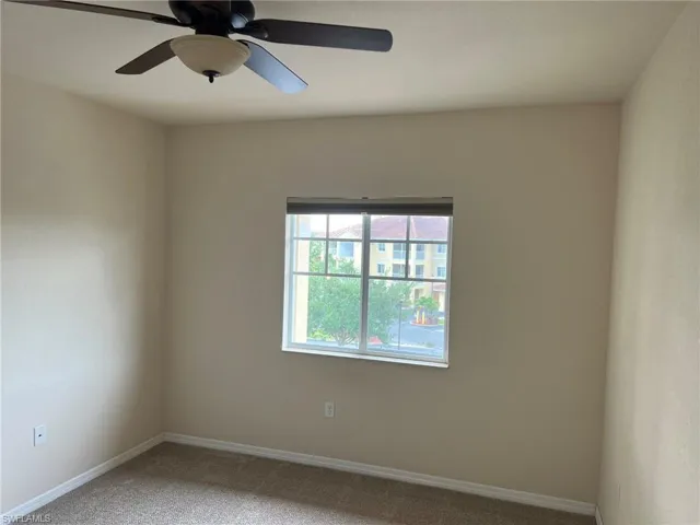 Unfurnished room featuring baseboards, a ceiling fan, and light colored carpet