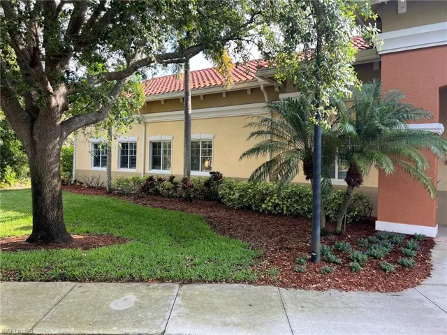 View of property exterior featuring a tile roof, a lawn, and stucco siding
