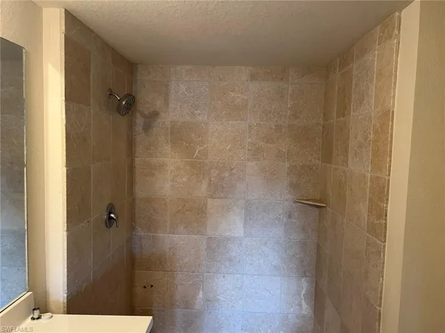 Details featuring tiled shower and a textured ceiling