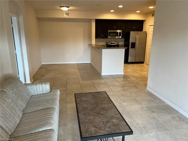 Kitchen featuring dark stone counters, a peninsula, visible vents, recessed lighting, and stainless steel appliances