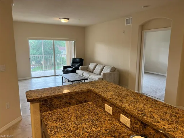 Living area featuring visible vents, baseboards, and light tile patterned flooring