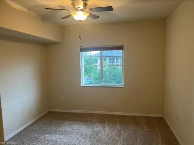 Empty room featuring ceiling fan, carpet flooring, and baseboards