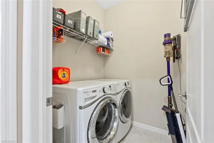 Laundry room with light tile patterned floors and independent washer and dryer