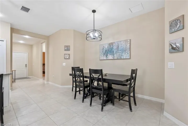 Tiled dining area with a chandelier
