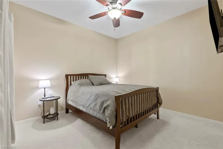 Carpeted bedroom featuring ceiling fan