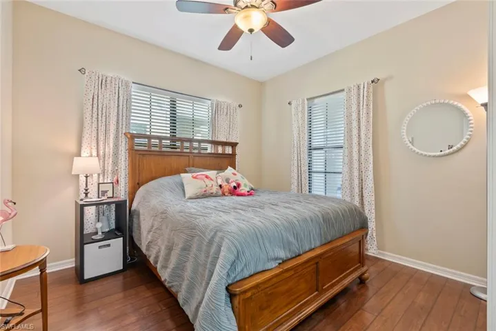 Bedroom with dark wood-type flooring and ceiling fan