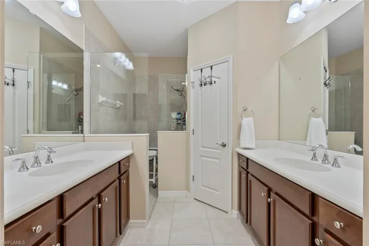 Bathroom with vanity, tiled shower, and tile patterned floors