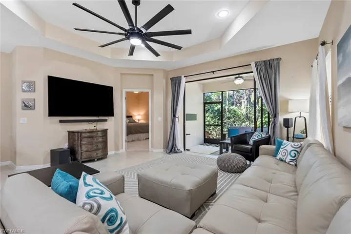 Living room featuring ceiling fan and a raised ceiling