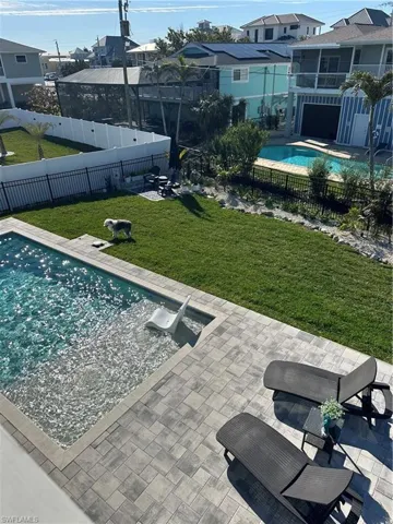 View of swimming pool with a patio, a fenced backyard, and a sunroom